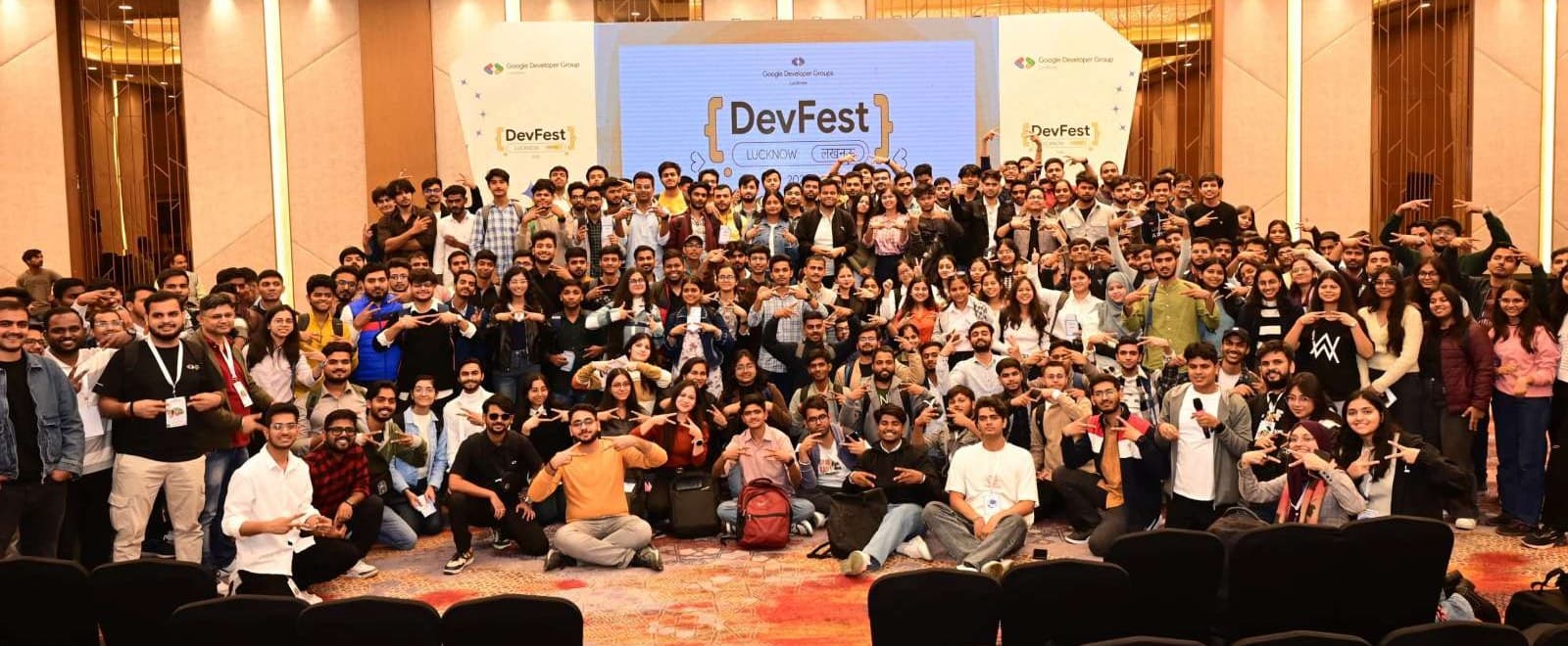 Several hundred DevFest Lucknow attendees posing together in front of the main stage